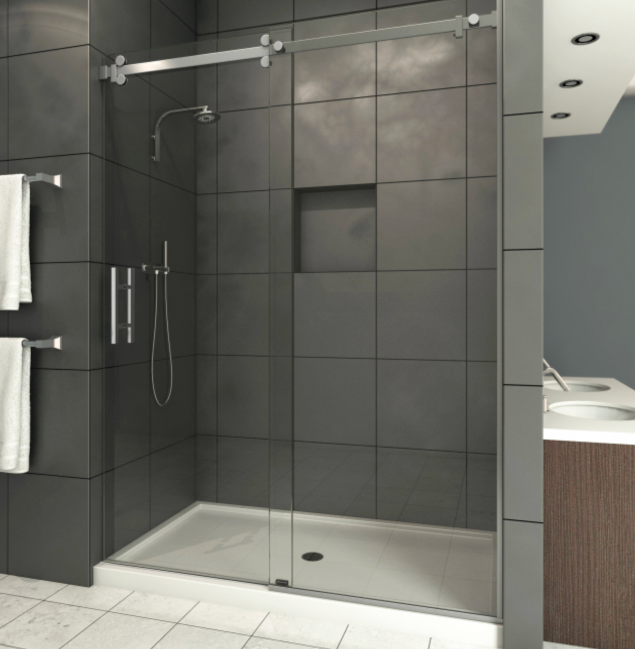 Modern shower with gray tile walls, glass door, and chrome fixtures.