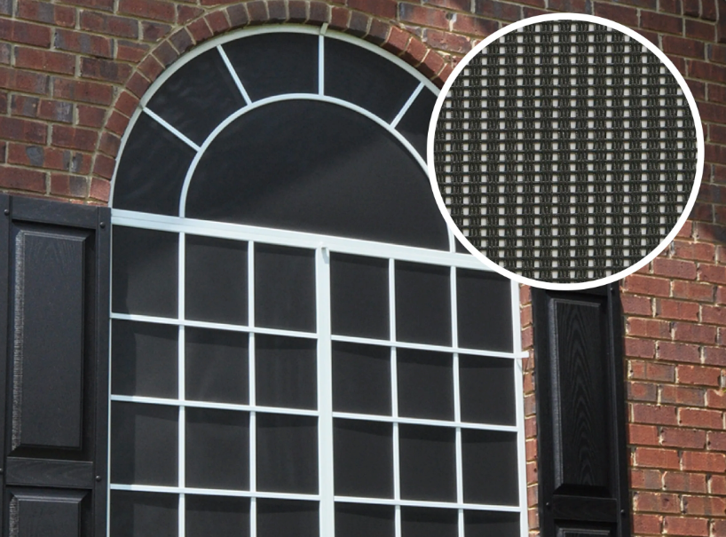 Arched window with black screen and white frame against a brick wall, with an inset of the screen material.