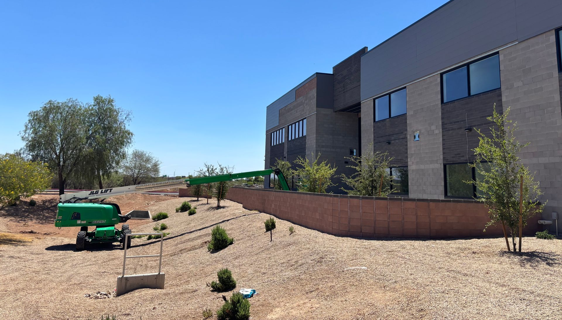 Modern shower with gray tiled walls, glass door, and built-in bench.