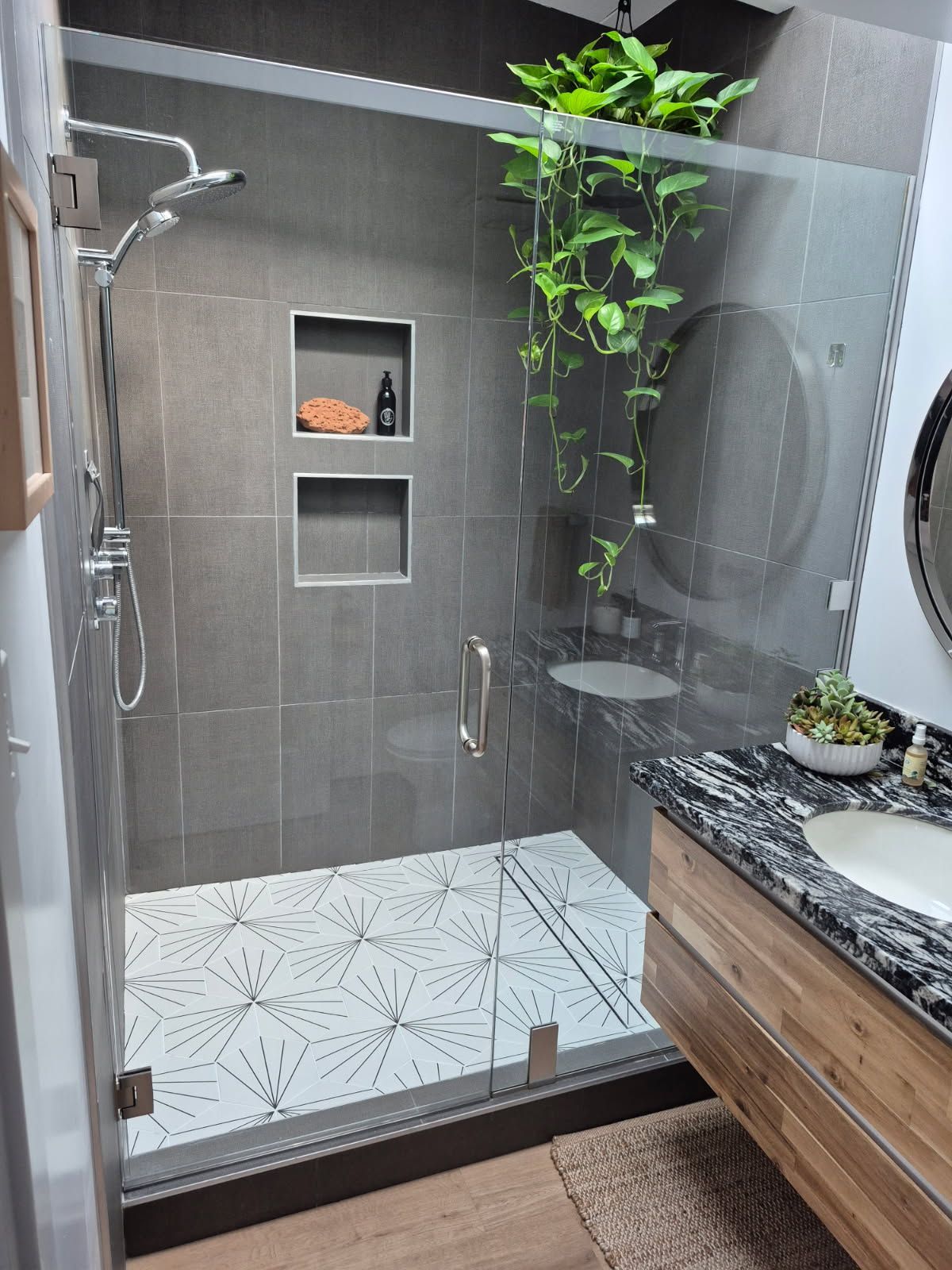 A modern, light-filled bathroom with a glass shower, vanity, and freestanding tub.