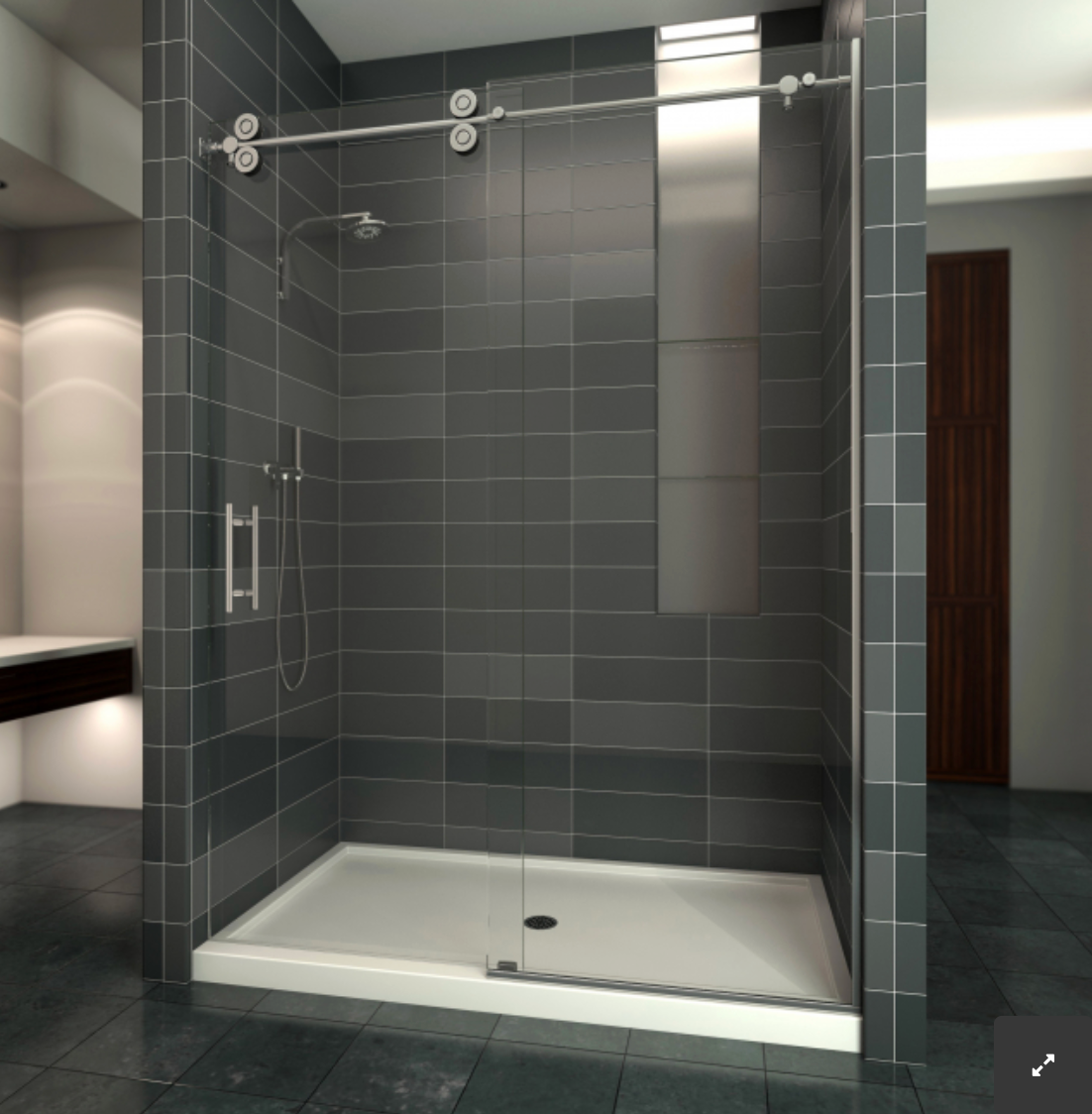 Modern shower with dark gray tiled walls, glass sliding door, and white shower base.