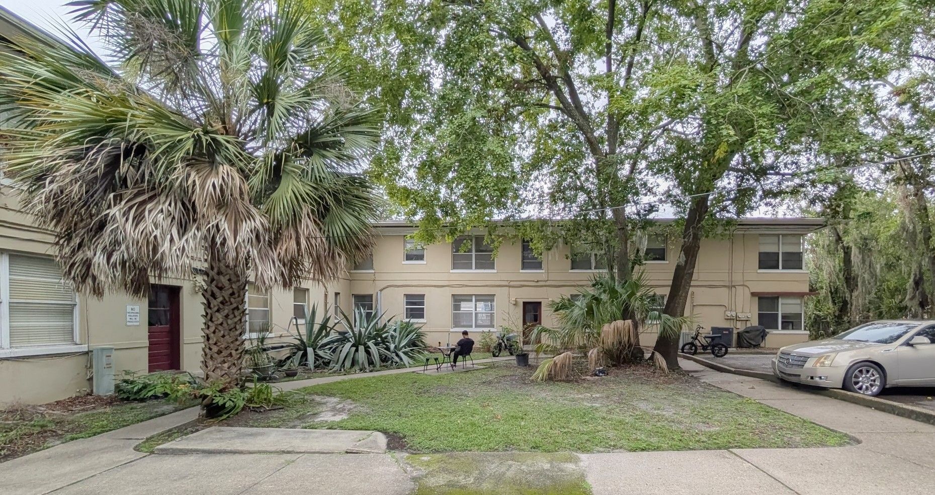 Playground on a bed of mulch, surrounded by grass and trees.