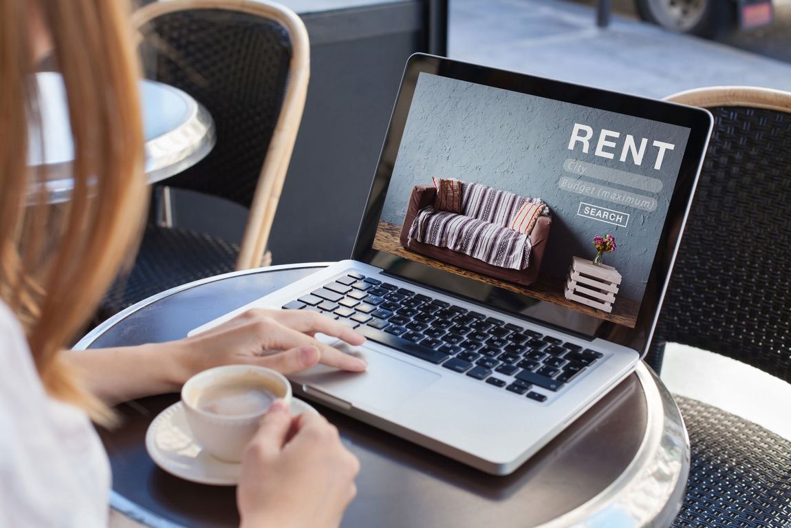 A person browsing rentals on their laptop