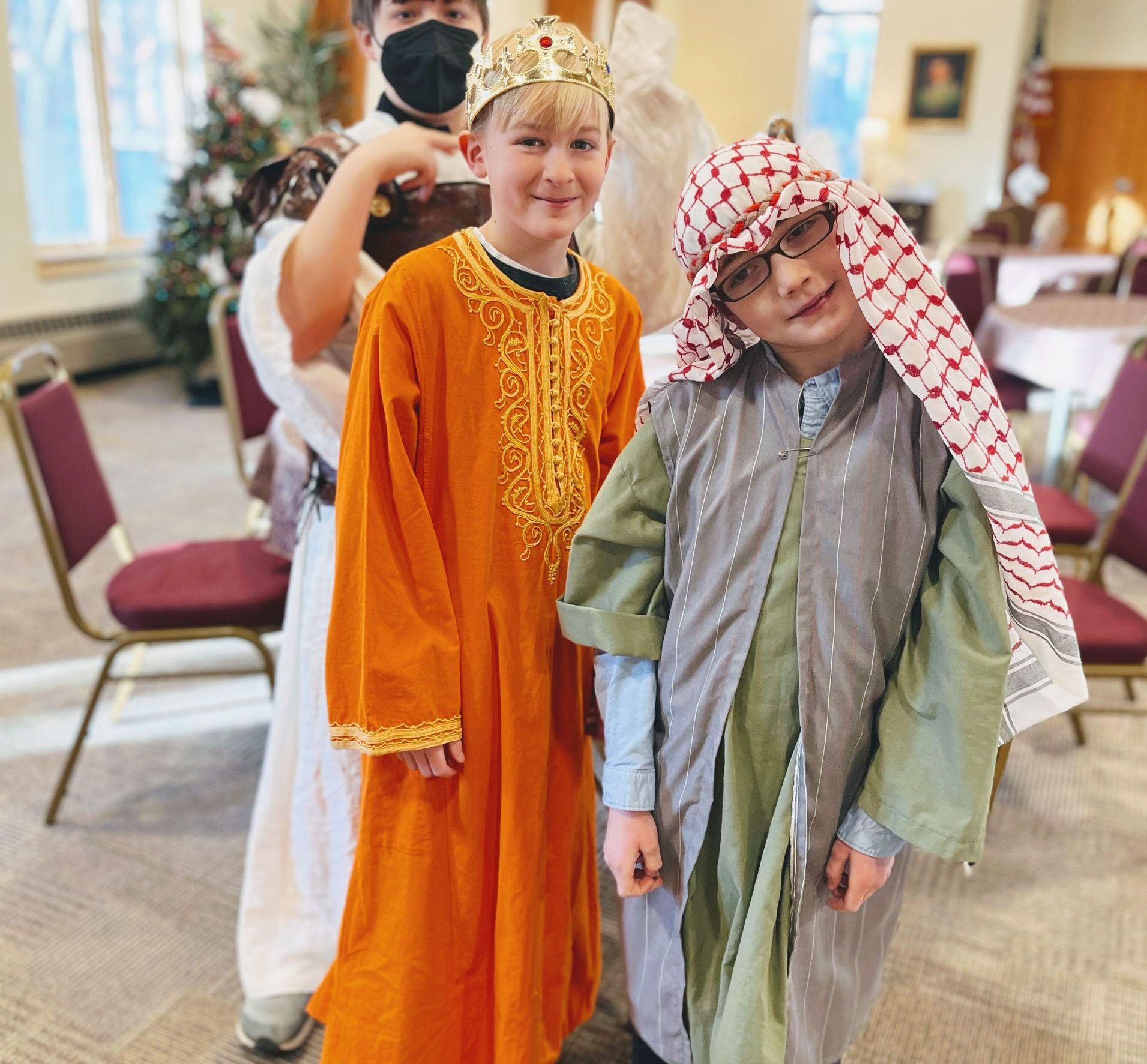 Three young boys dressed in costumes are posing for a picture