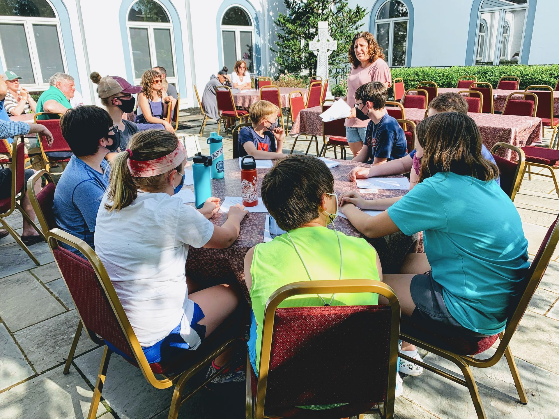 A group of people are sitting around a table outside
