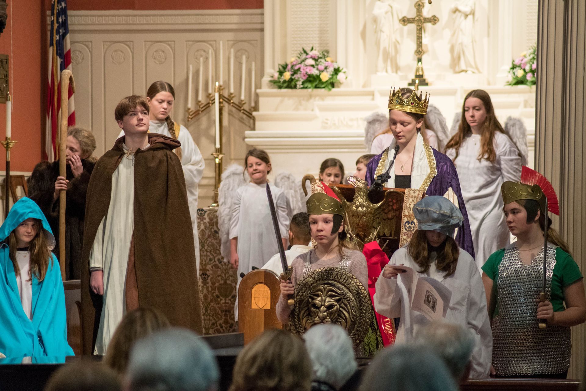 A group of children dressed in costumes are performing in a church