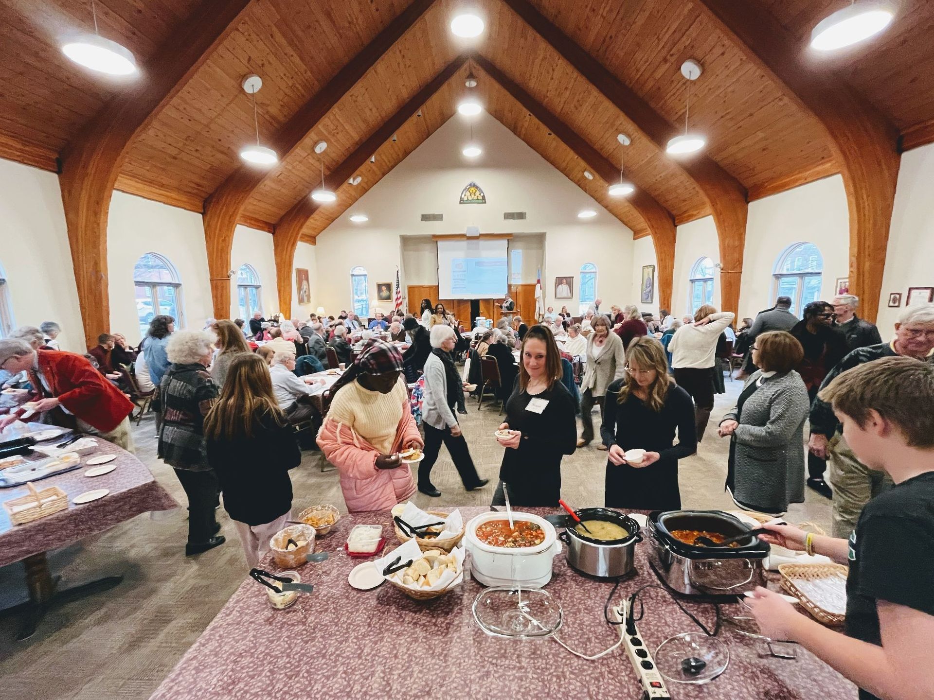 A large group of people are gathered in a church for a buffet