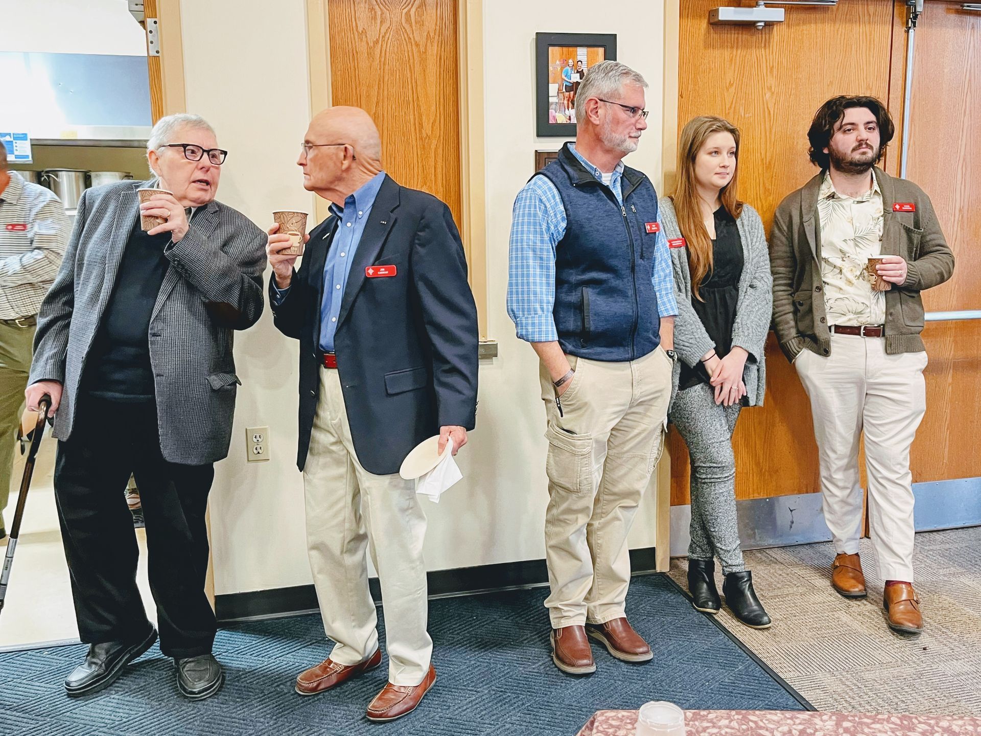 A group of people standing in front of a wooden door