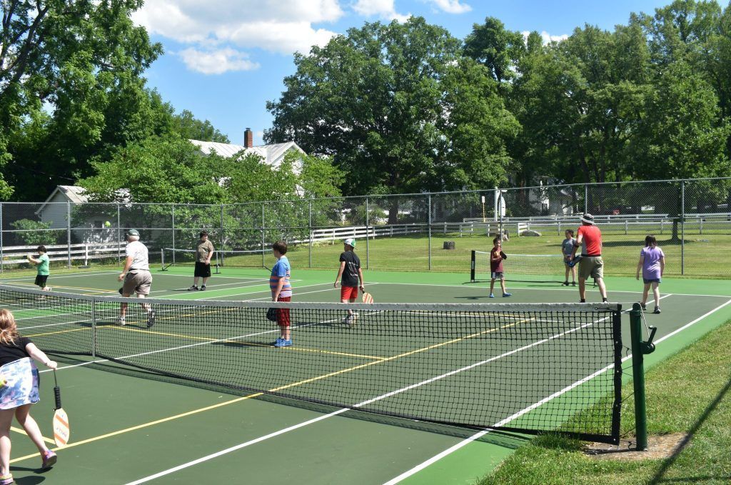 A group of people are playing tennis on a sunny day