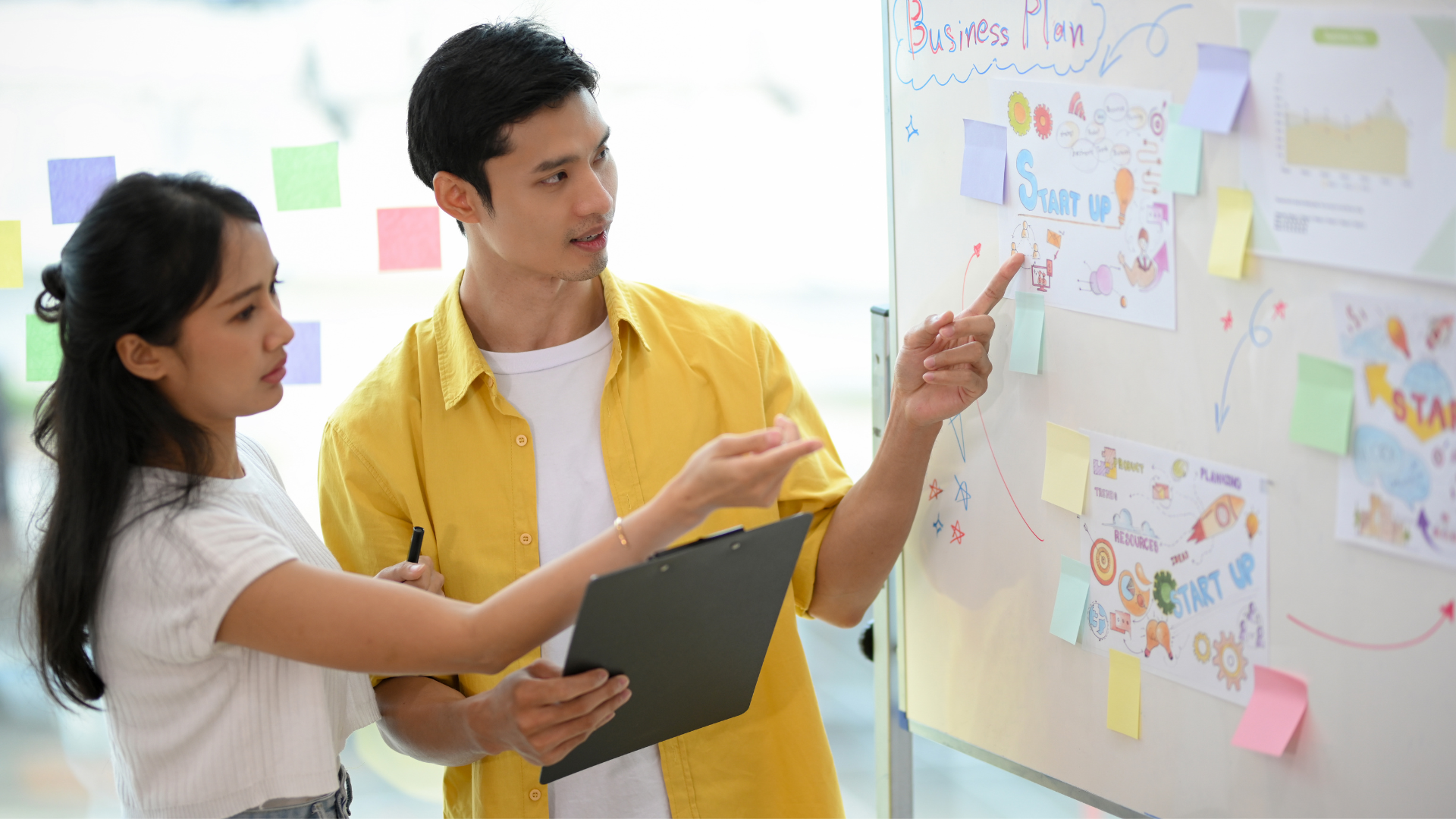 An image of a team brainstorming together at a white board, symbolizing creative collaboration. 