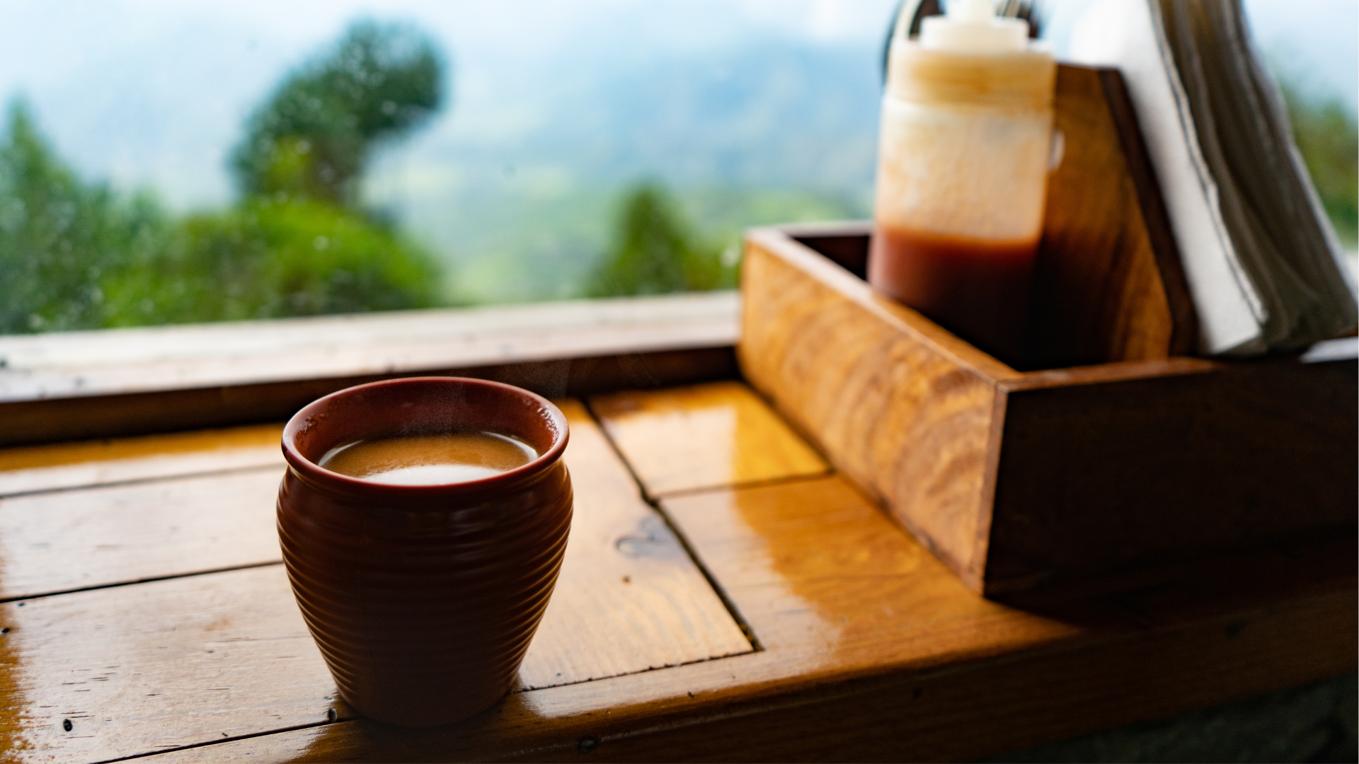 A serene, morning scene with a cup of chai tea, a bible, and light streaming through a window.