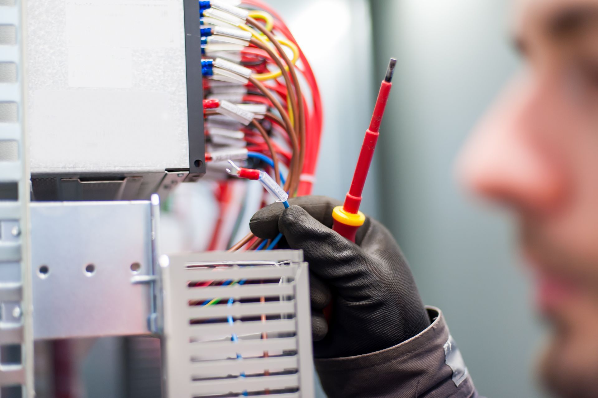 Person in Black Gloves Working on Electrical Wiring With a Screwdriver — Industry Fire Services in Ayr, QLD