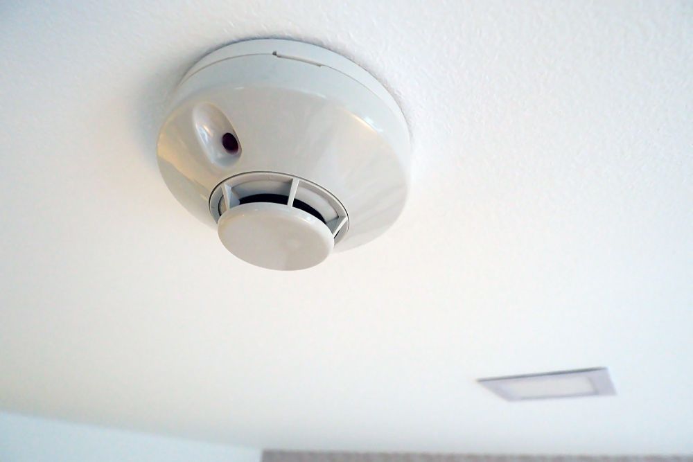 White Smoke Detector Mounted on a White Ceiling — Industry Fire Services in Bowen, QLD