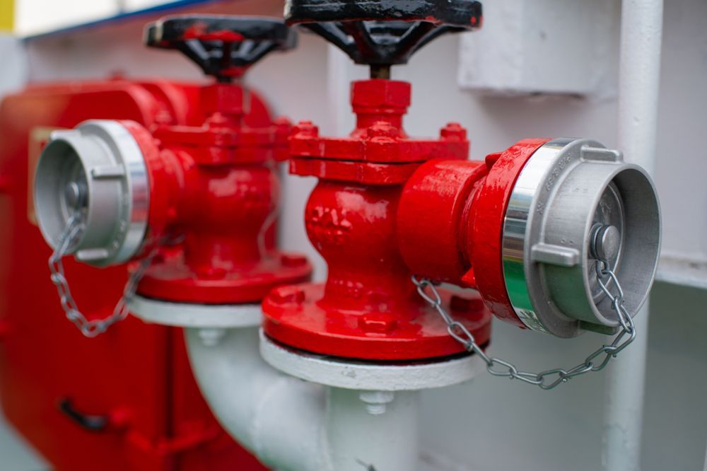 Red Fire Hydrants on a White Surface, With Silver-colored Hose — Industry Fire Services in Proserpine, QLD