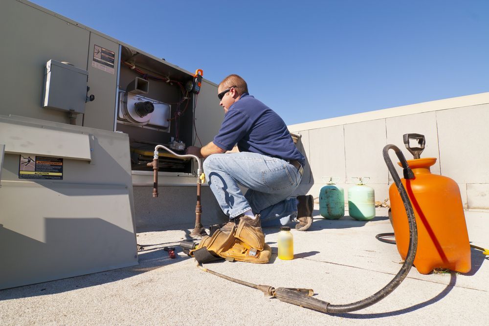 Hvac Technician Working on Rooftop Air Conditioning Unit — Industry Fire Services in Airlie Beach, QLD