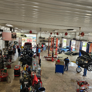 Interior of an auto repair shop with multiple cars on lifts and mechanics working. |Z-1 Automotive, Inc.