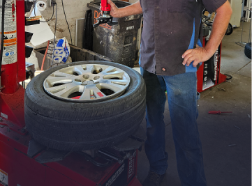 Mechanic working on a car brake rotor in a shop. | Z-1 Automotive, Inc.