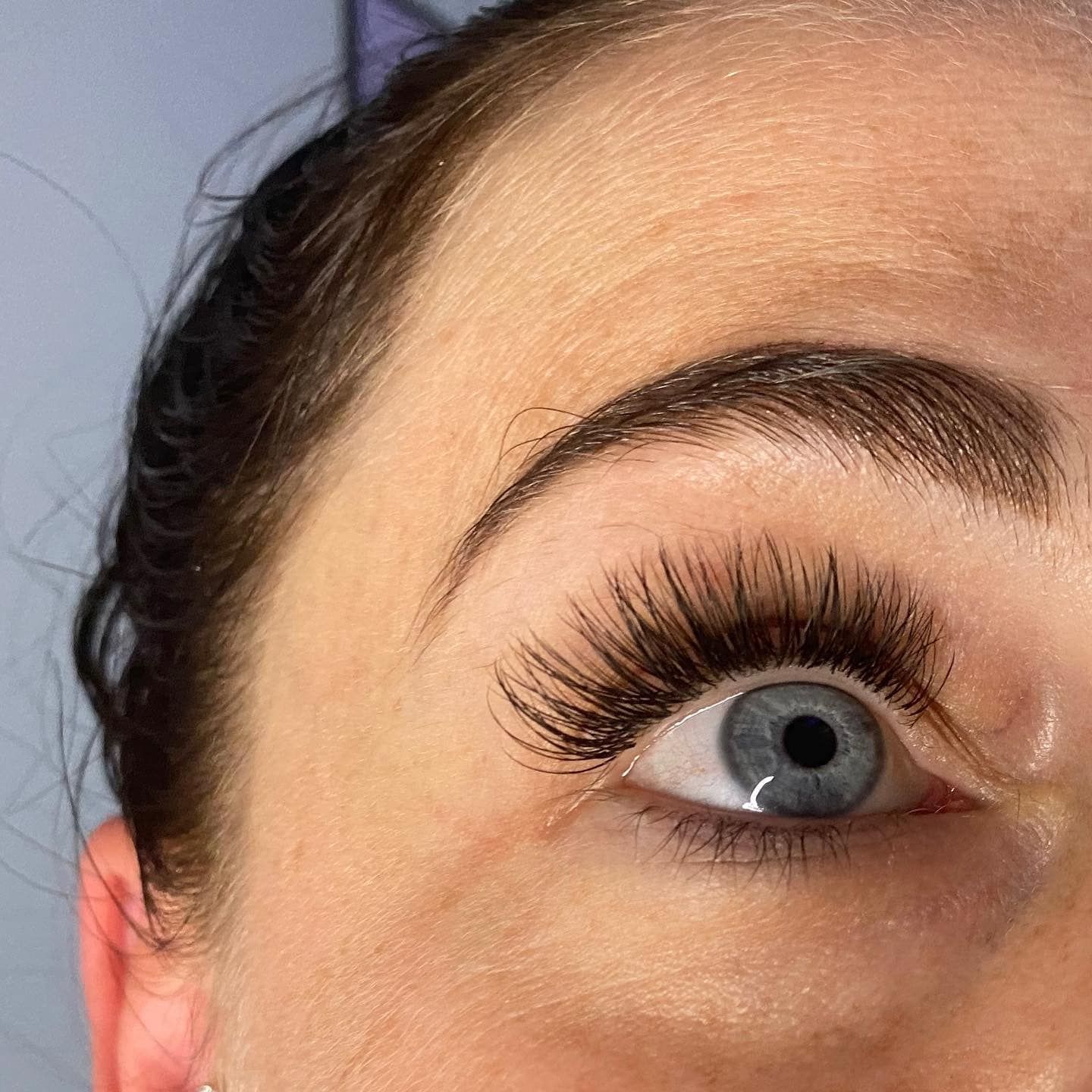 A close up of a woman 's eye with long eyelashes.