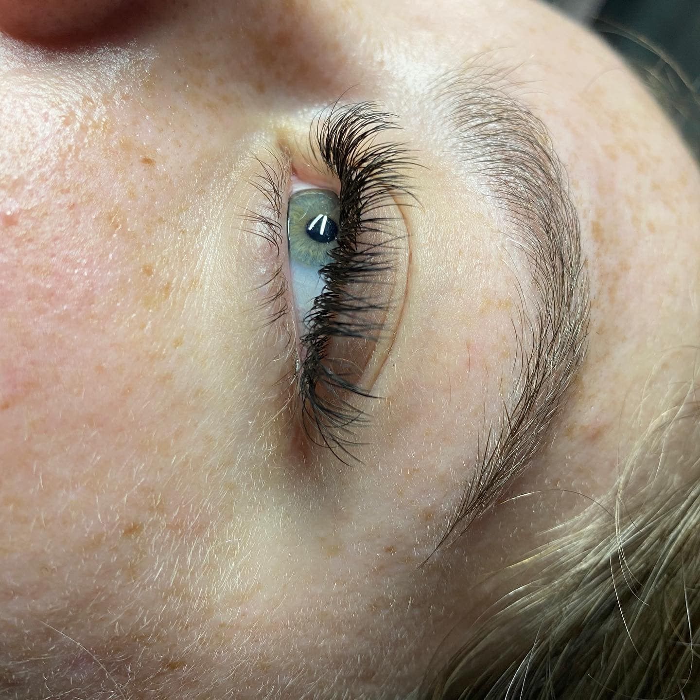 A close up of a woman 's eye with long eyelashes