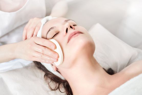 A woman is getting a facial treatment at a spa.