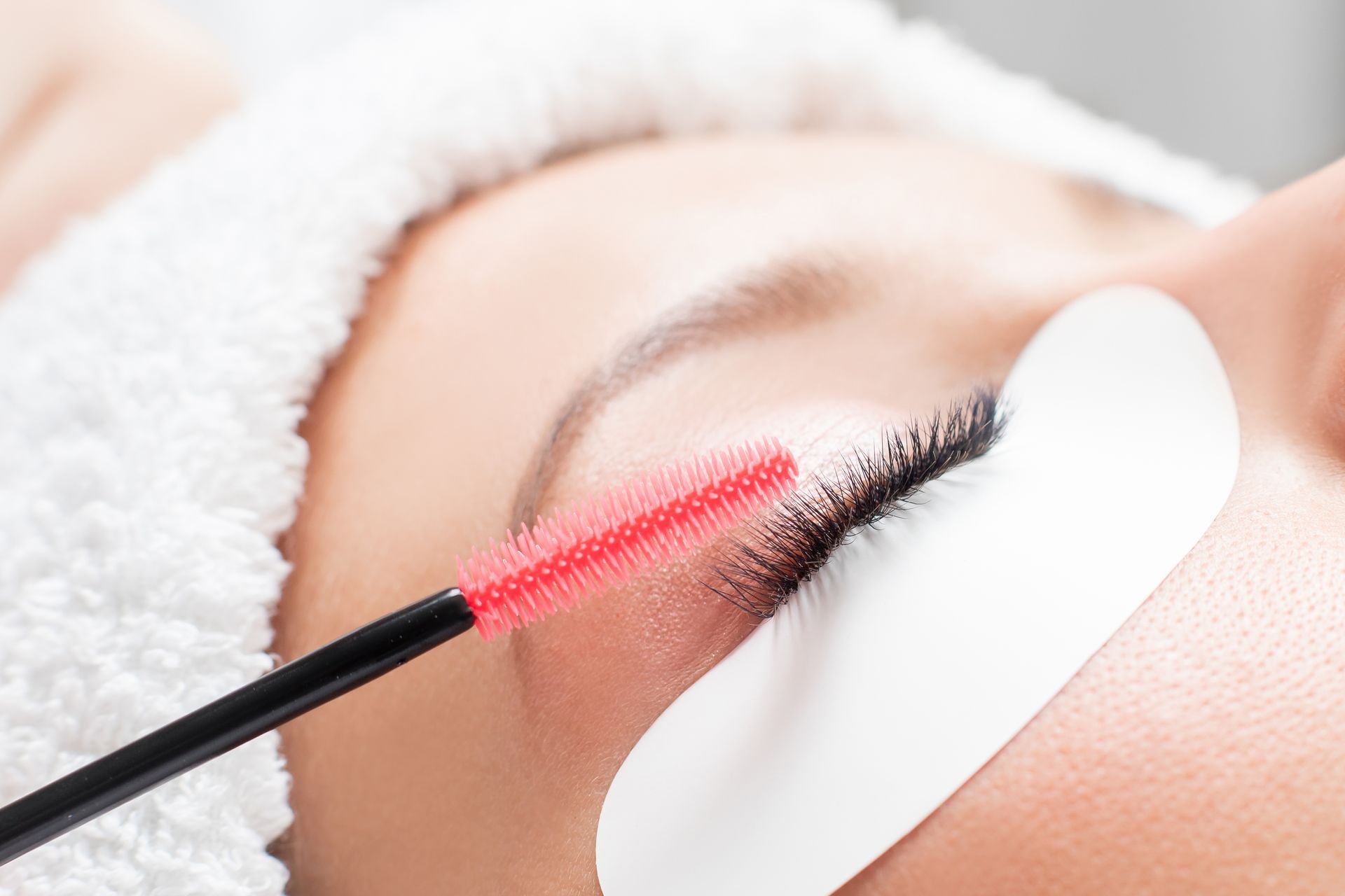A woman is getting her eyelashes done at a beauty salon.
