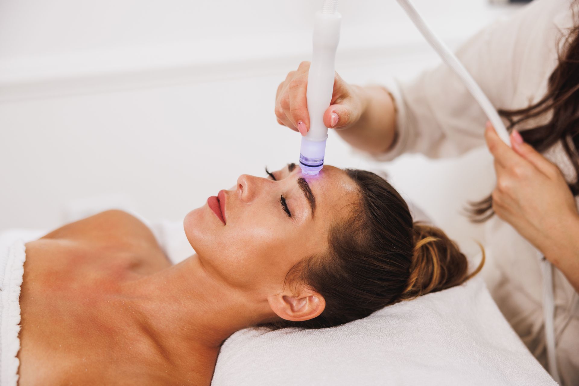 A woman is getting a facial treatment at a spa. Hydrafacial.