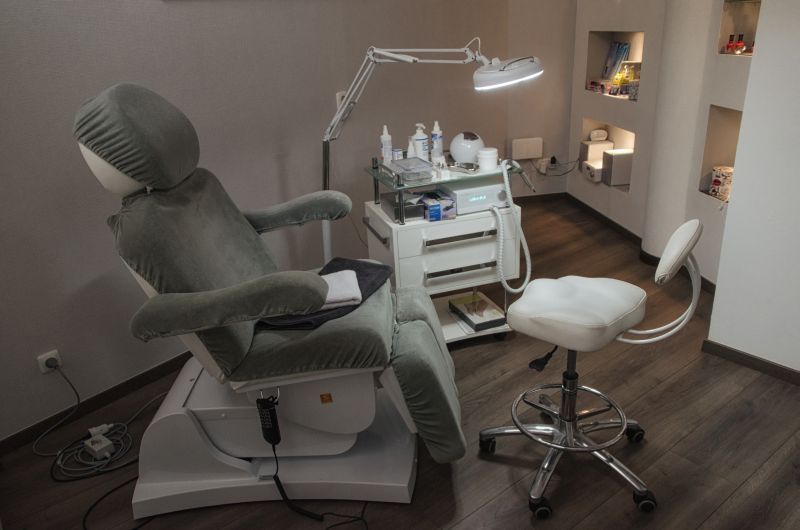 Ein Stuhl in einem Raum mit einer Lampe und einem Hocker.