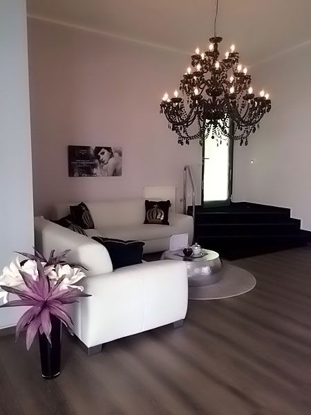 Ein Wohnzimmer mit einem Sofa, einem Sessel und einem Kronleuchter