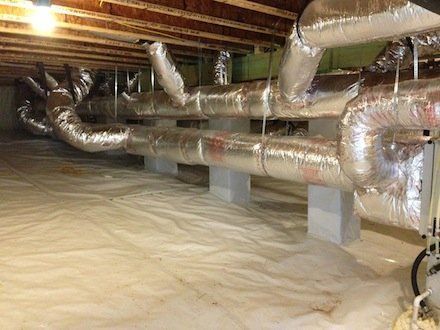 Crawlspace with HVAC ductwork and white plastic sheeting on the ground.