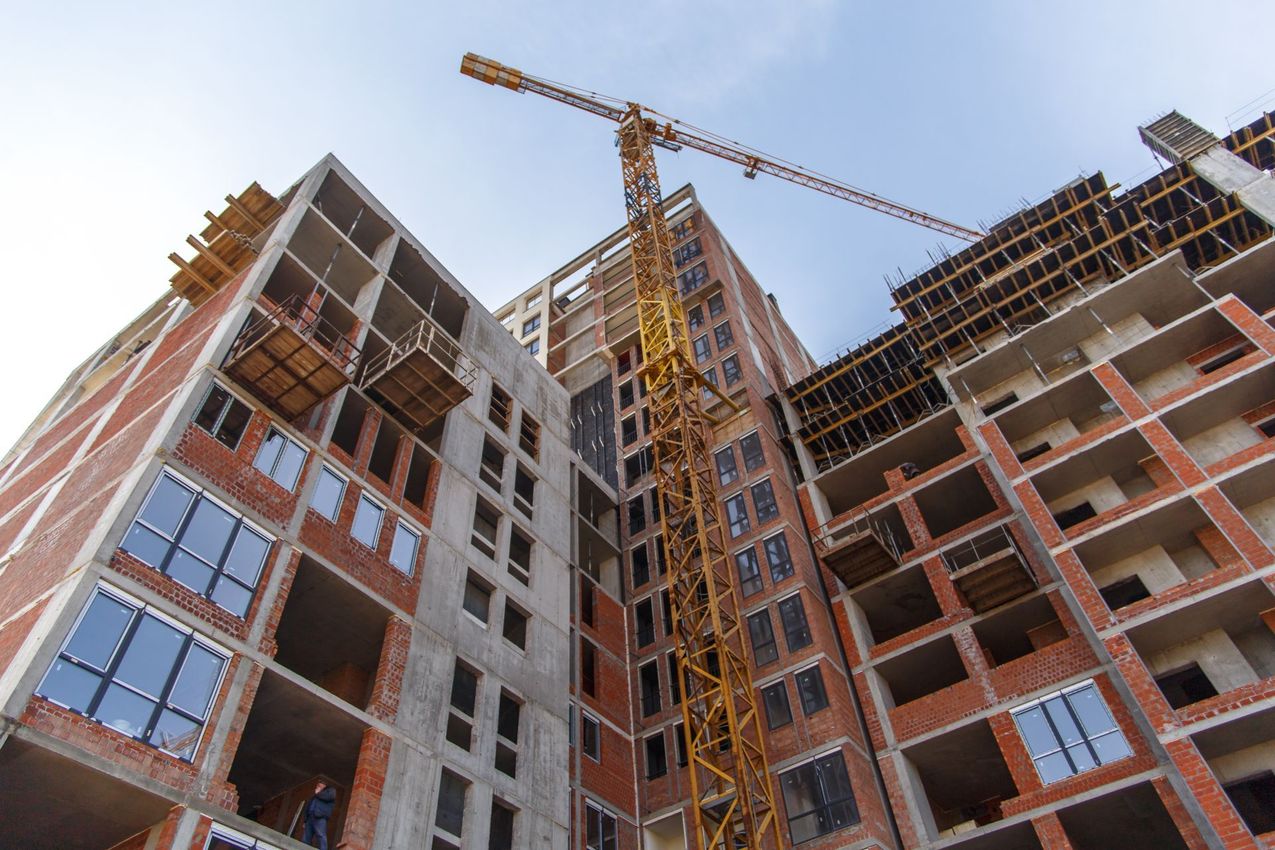 A building under construction with a crane in front of it.