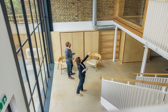 An Asian female real estate agent showing a new office space to clients