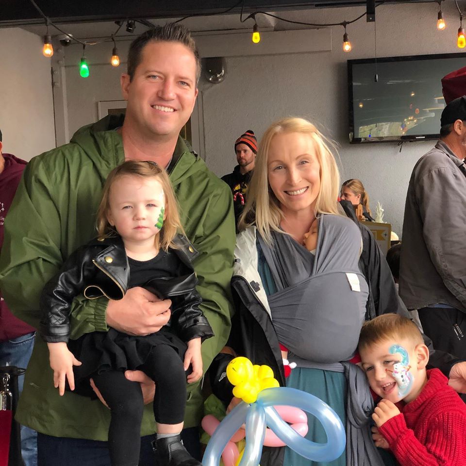 A group of people posing for a picture including a woman holding a baby