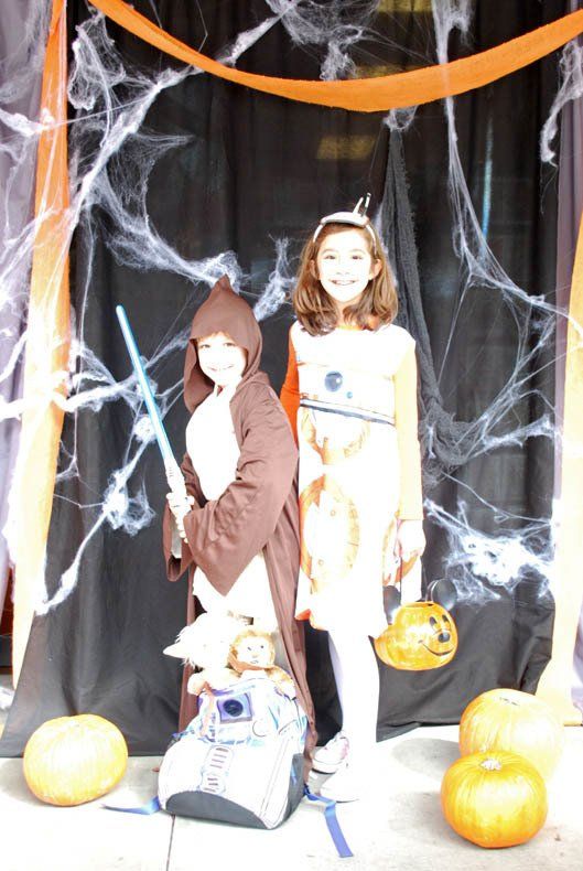 Two children in halloween costumes pose for a picture