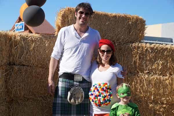 A family posing for a picture in front of hay bales