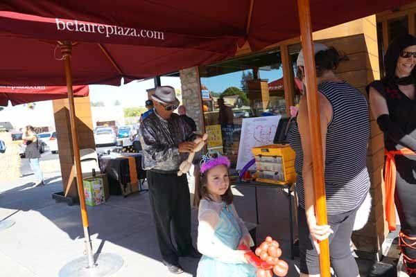 A little girl stands under an umbrella that says betareplaza.com