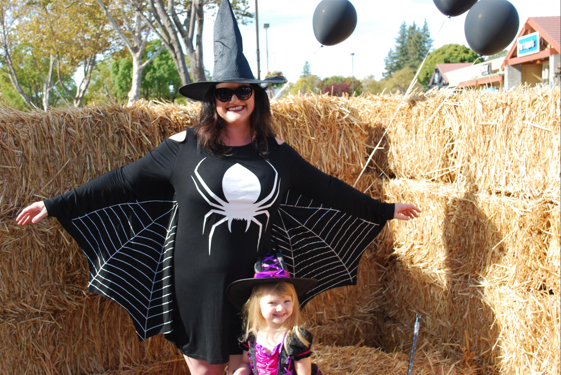 A woman in a witch costume is standing next to a little girl in a witch costume.