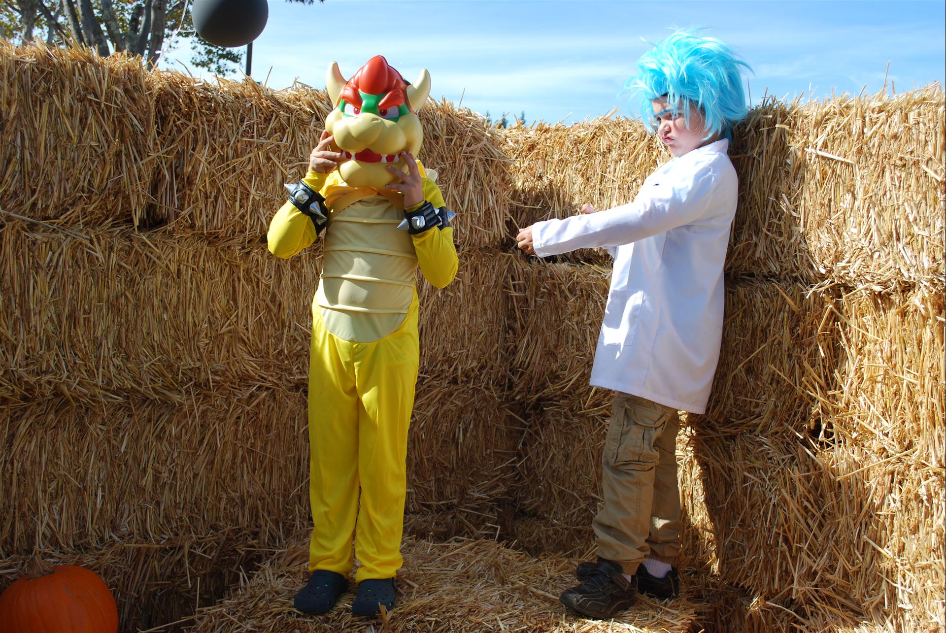 A boy in a bowser costume is standing next to a boy in a lab coat.