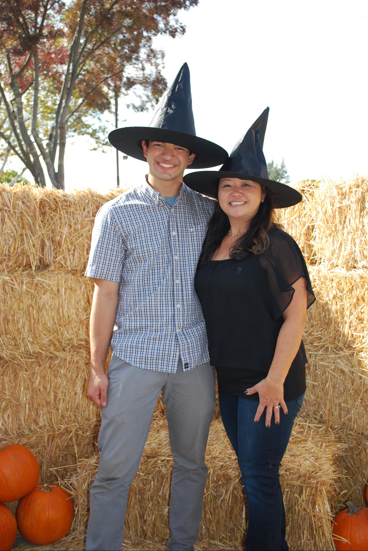 A man and a woman wearing witch hats are posing for a picture.