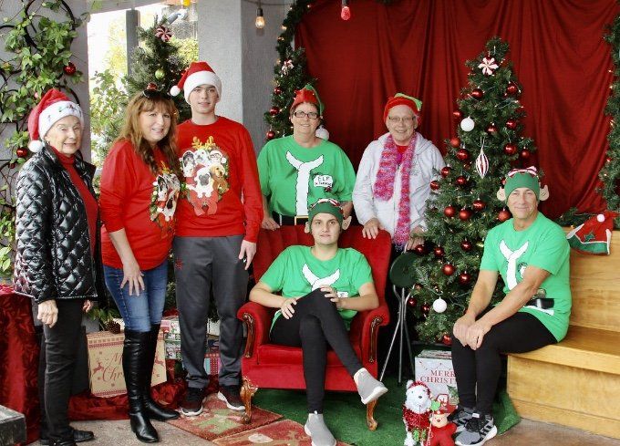 A group of people are posing for a picture in front of a christmas tree.