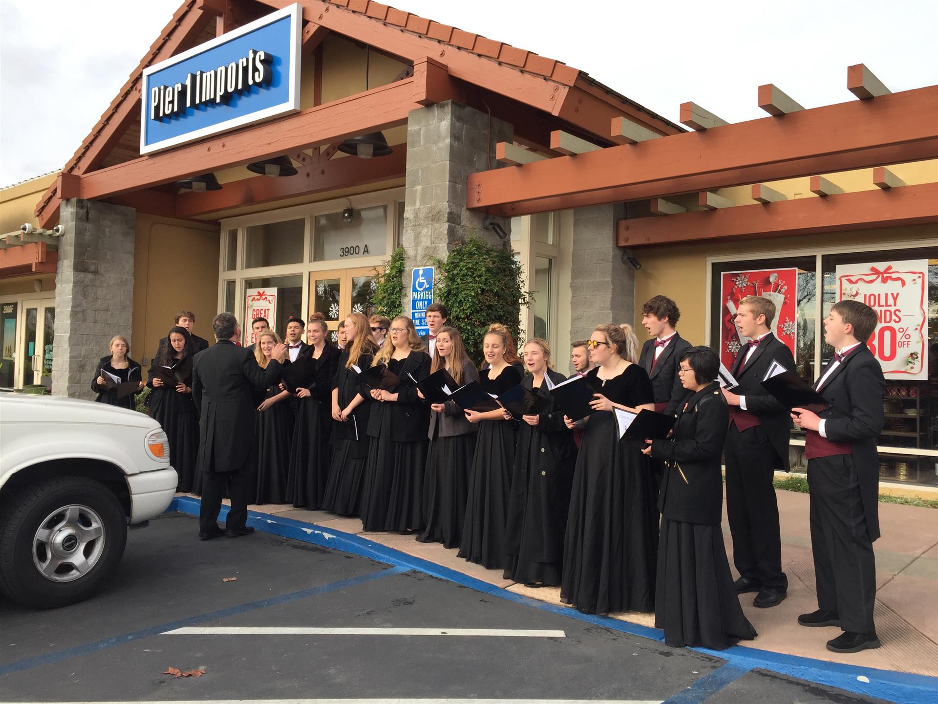 A choir is singing in front of a store.