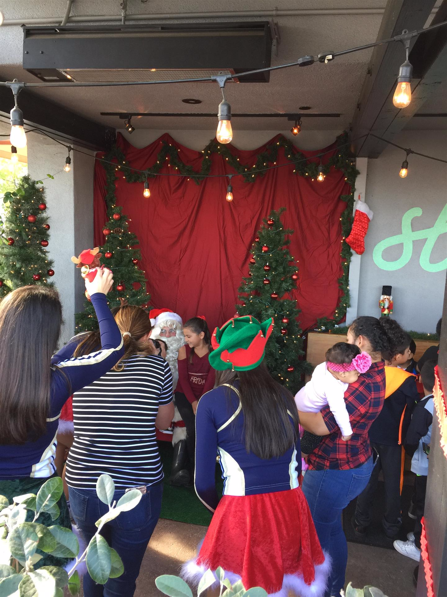 A group of people are standing in front of a christmas tree.