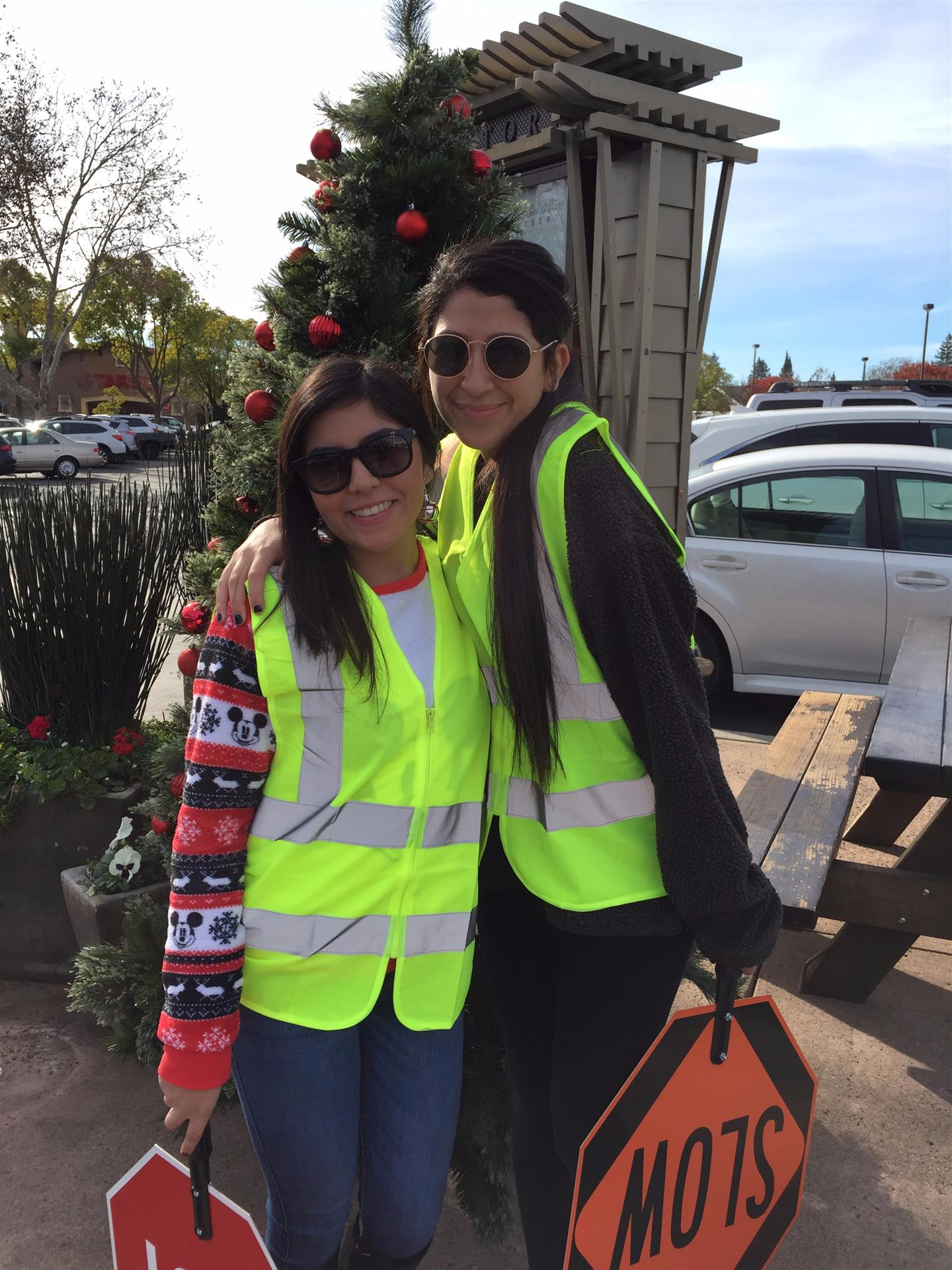 Two women standing next to each other holding a sign that says slow