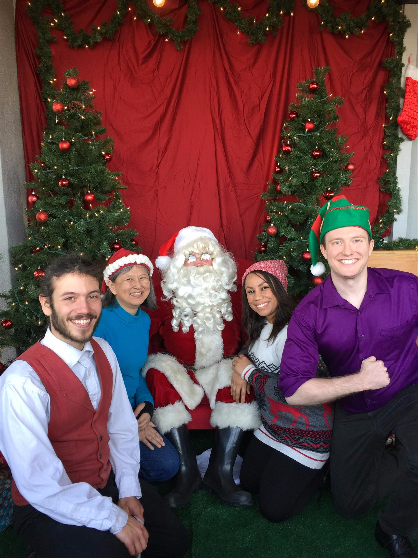 A group of people posing for a picture with santa claus