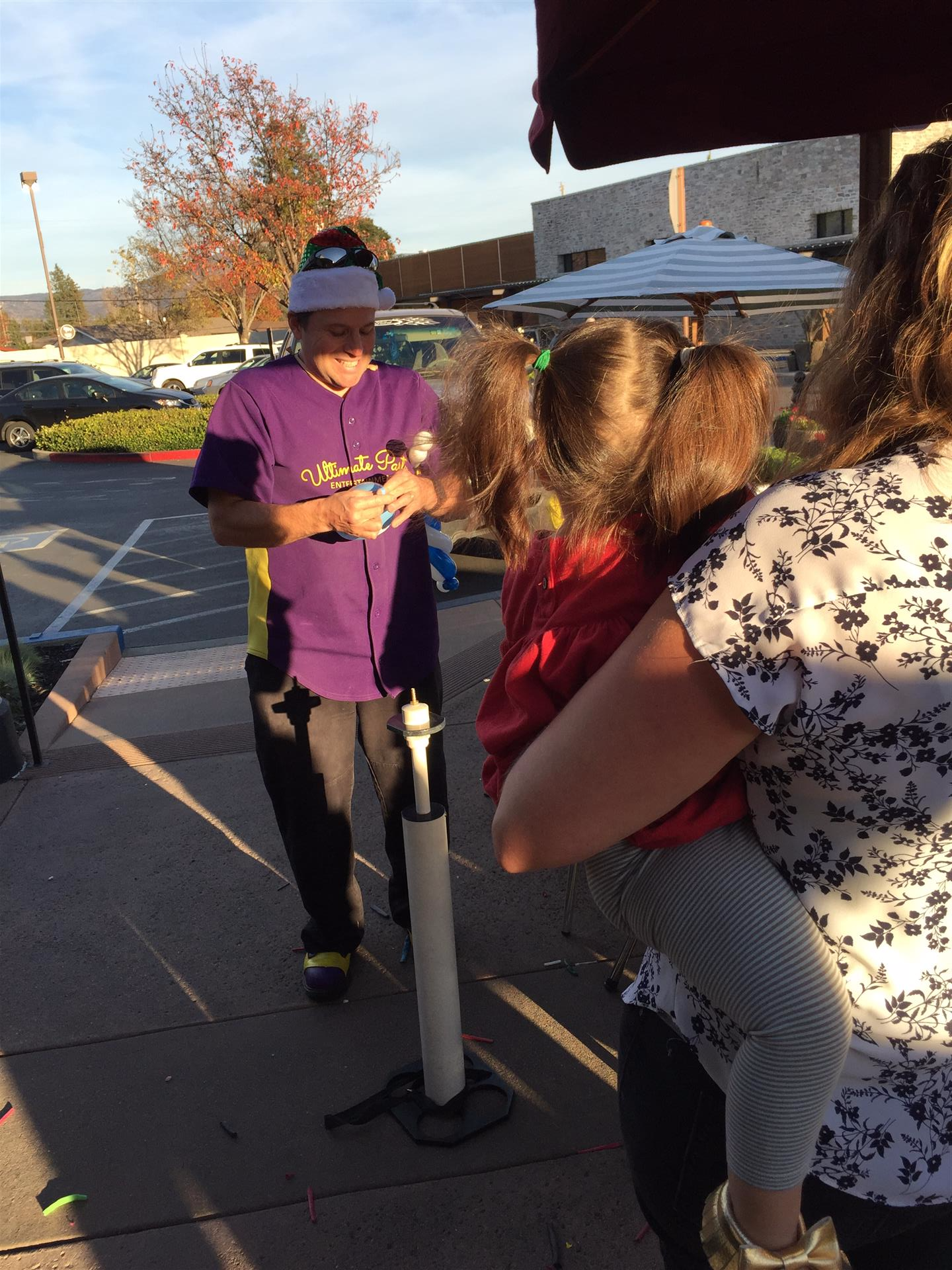 A man in a purple shirt is holding a little girl