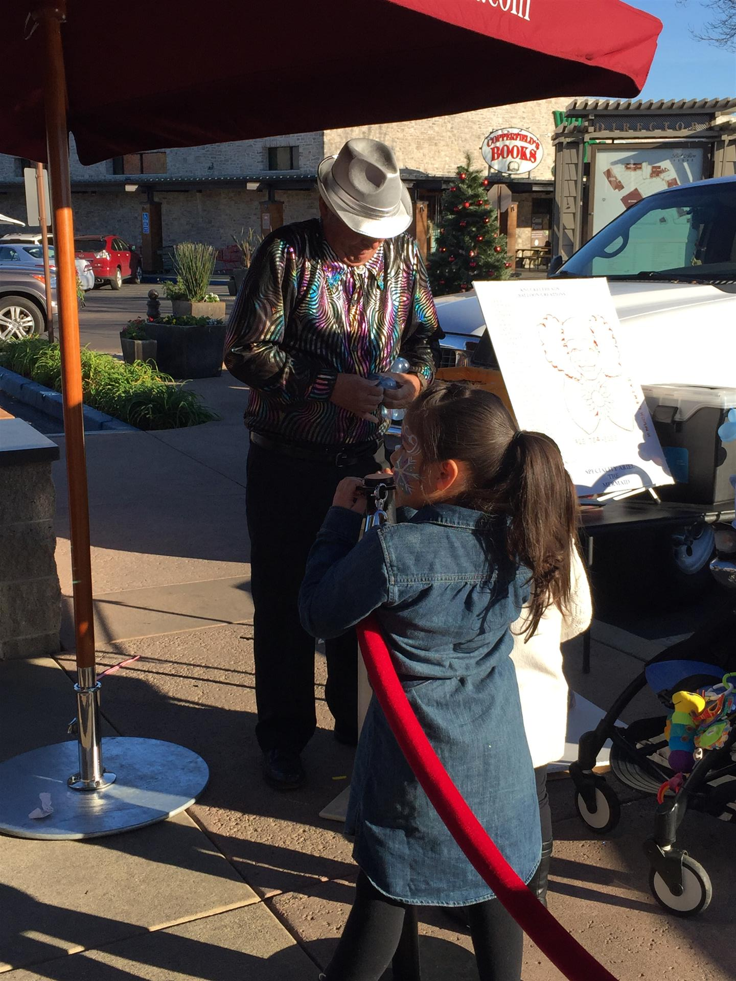 A little girl standing next to a man under an umbrella