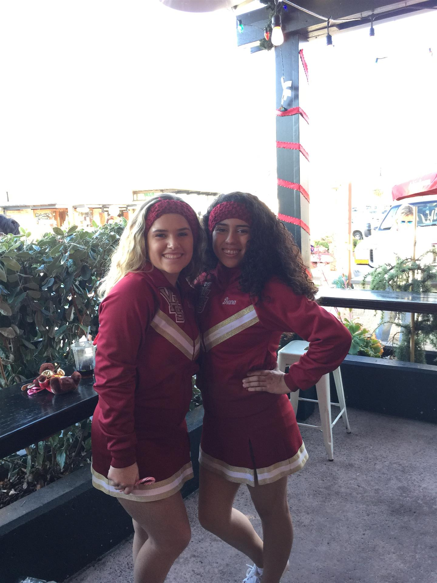 Two cheerleaders are posing for a picture together.