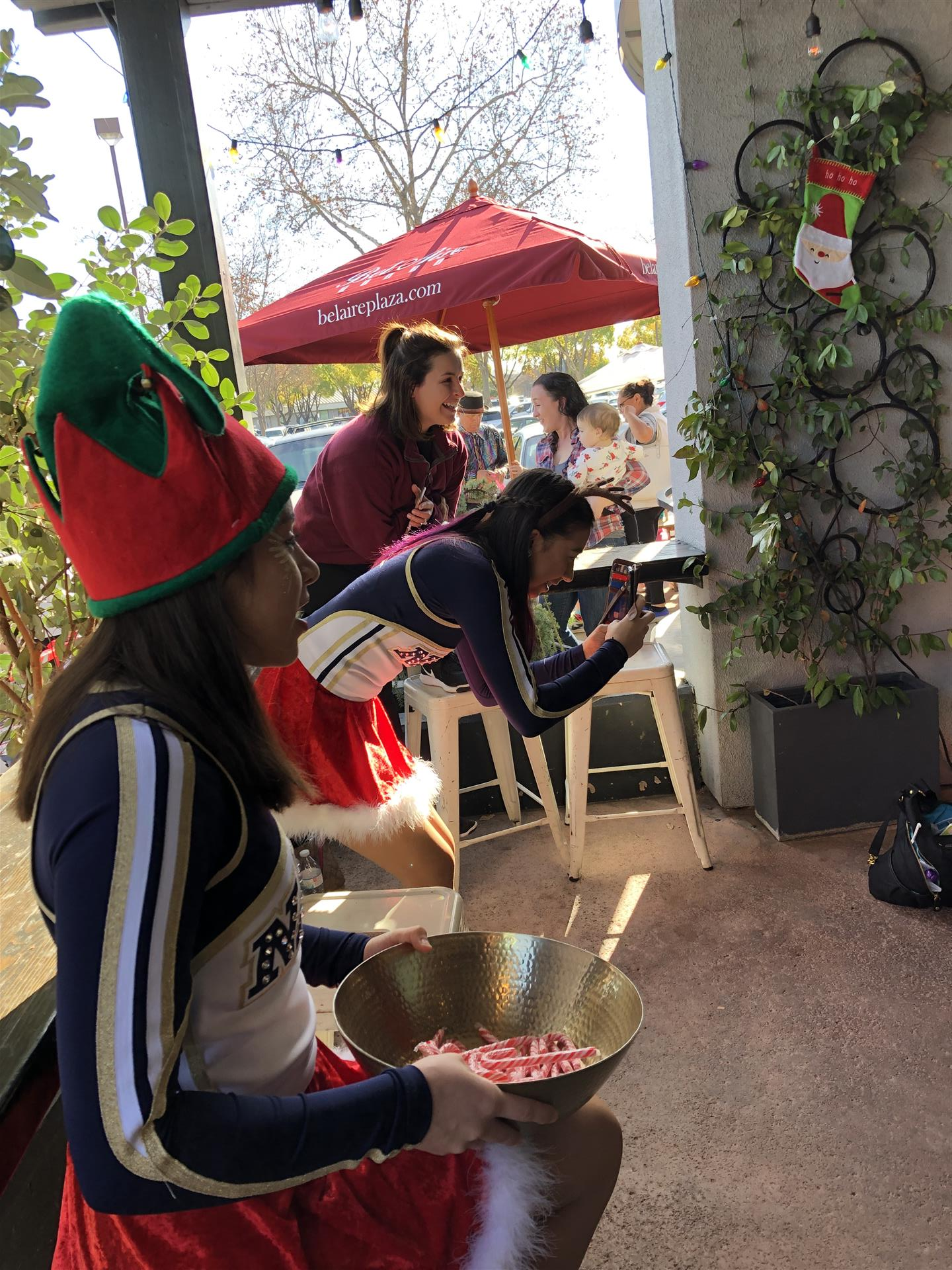 A woman in an elf hat is holding a bowl of food.