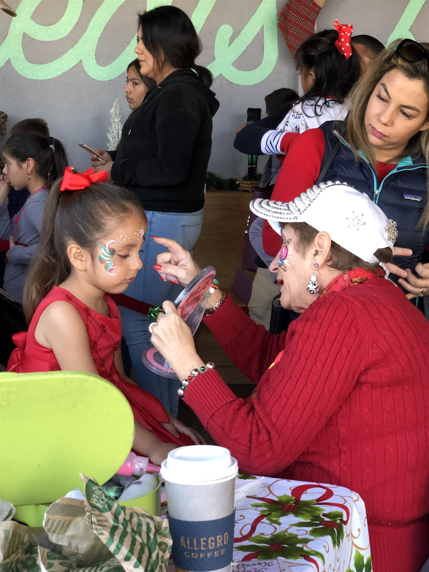 A woman is painting a little girl 's face.