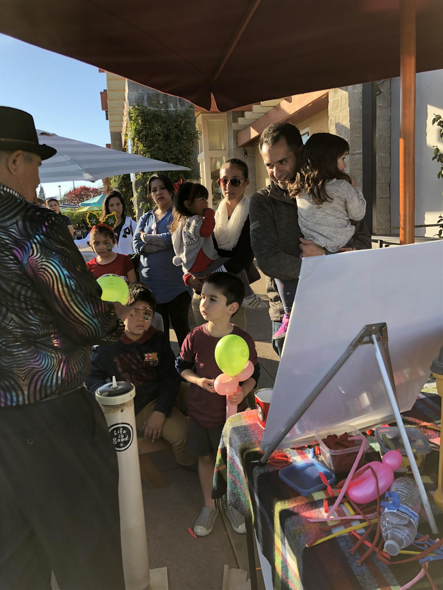A man is standing in front of a group of people holding balloons.
