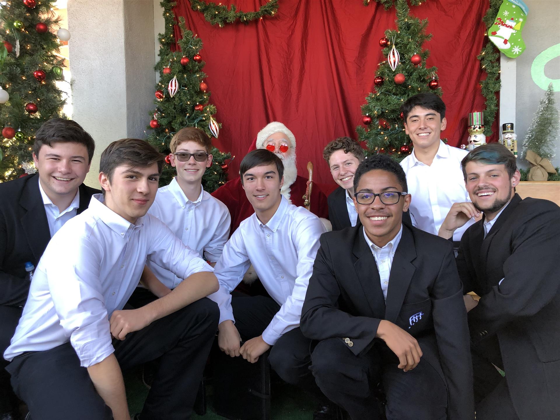 A group of young men are posing for a picture with santa claus.